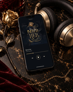 Bend Her audiobook on a phone beside black-and-gold headphones, a gold rose, and burgundy velvet