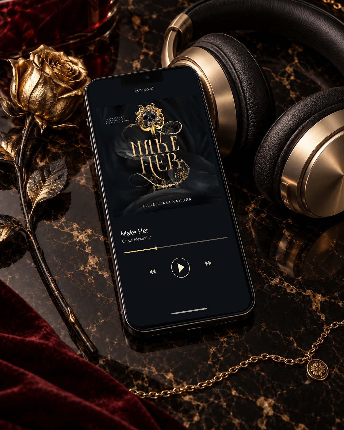Make Her audiobook on a phone beside black-and-gold headphones, a gold rose, and burgundy velvet
