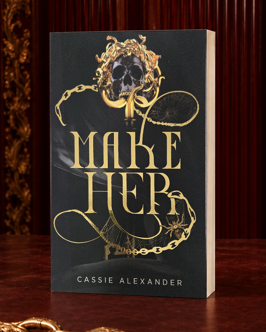 Make Her black-and-gold foil paperback in an oxblood editorial setting