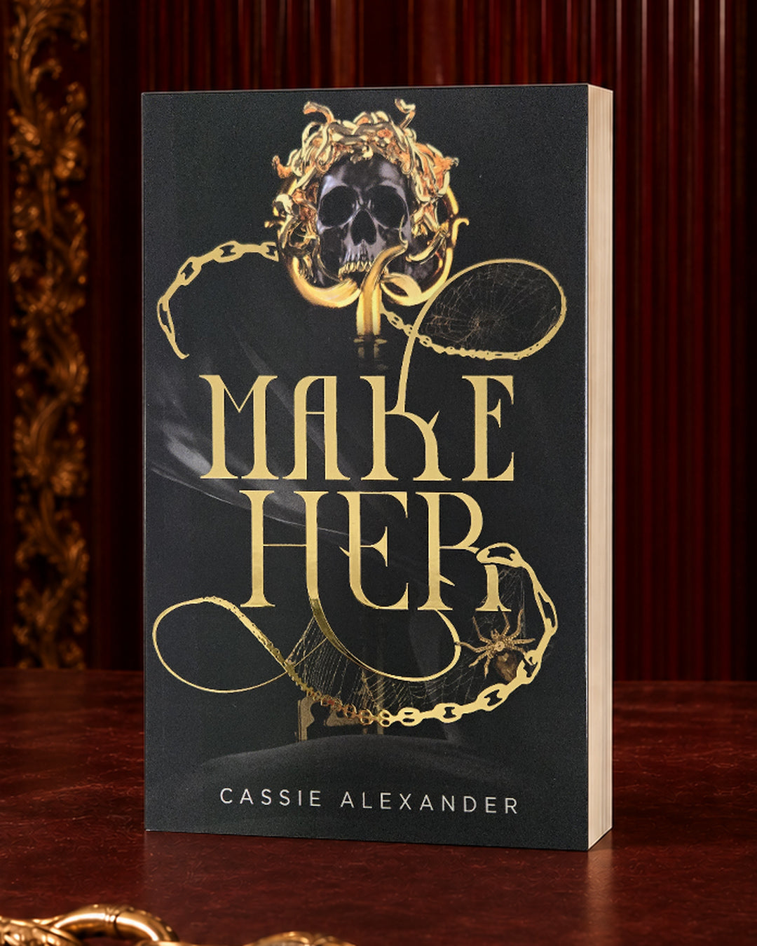Make Her black-and-gold foil paperback in an oxblood editorial setting